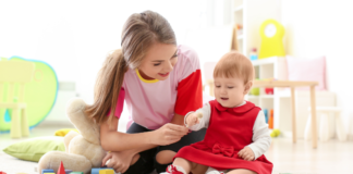 A babysitter watching a toddler.