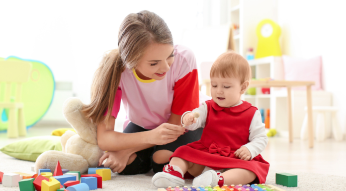 How to Hire a Babysitter A babysitter watching a toddler.