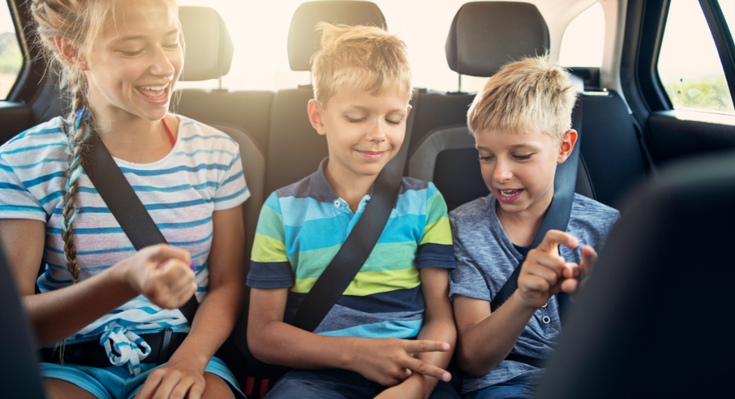 Kids sitting in the back seat of the car on a road trip.