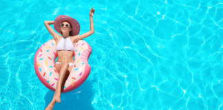 A mom relaxing in a pool on a float.