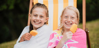 Two girls eating popsicles.