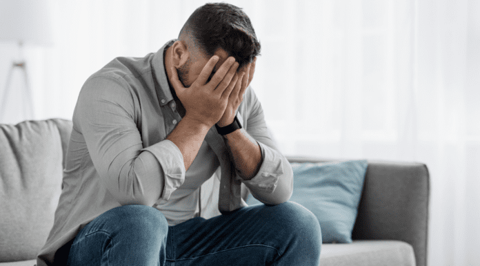 A man holding his face upset.