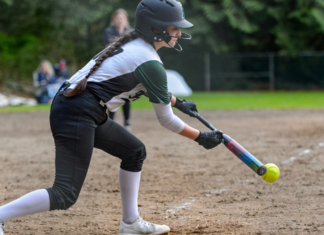 A girl playing softball.
