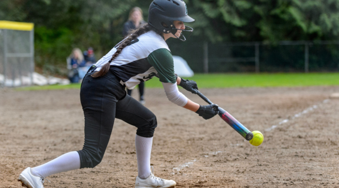 A girl playing softball.