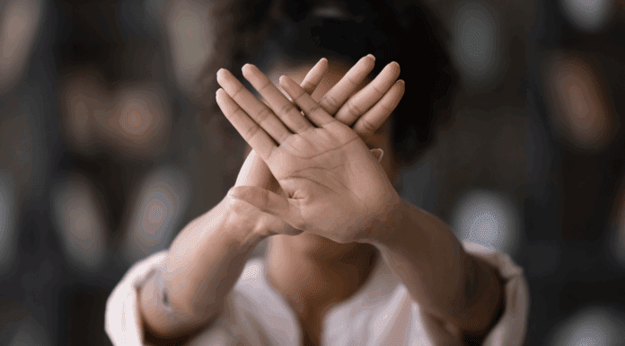 A woman holding up her hands saying stop.