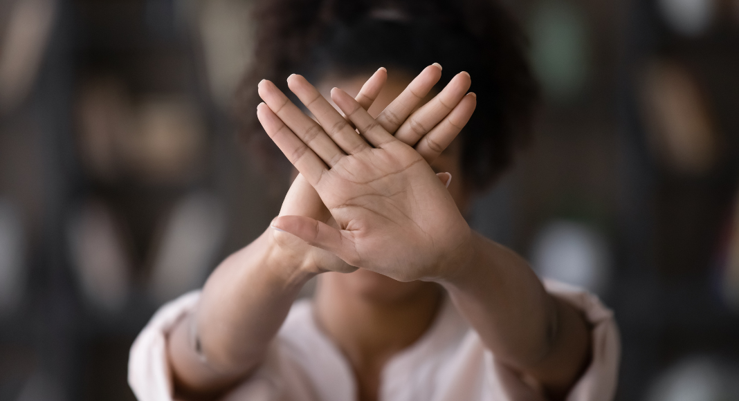  A woman holding up her hands saying stop.