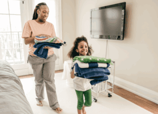 A mom and daughter putting away folded laundry.