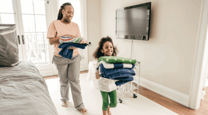 A mom and daughter putting away folded laundry.