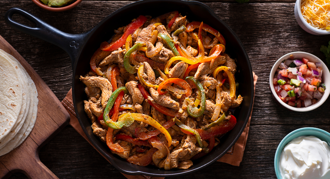 Chicken fajitas in a skillet.