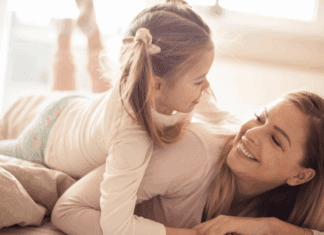 Mom Guilt: Let it Go! A woman laying down with her daughter on top of her smiling.
