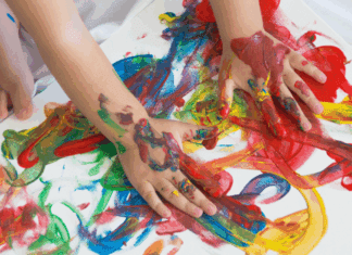 A child's hands finger painting.