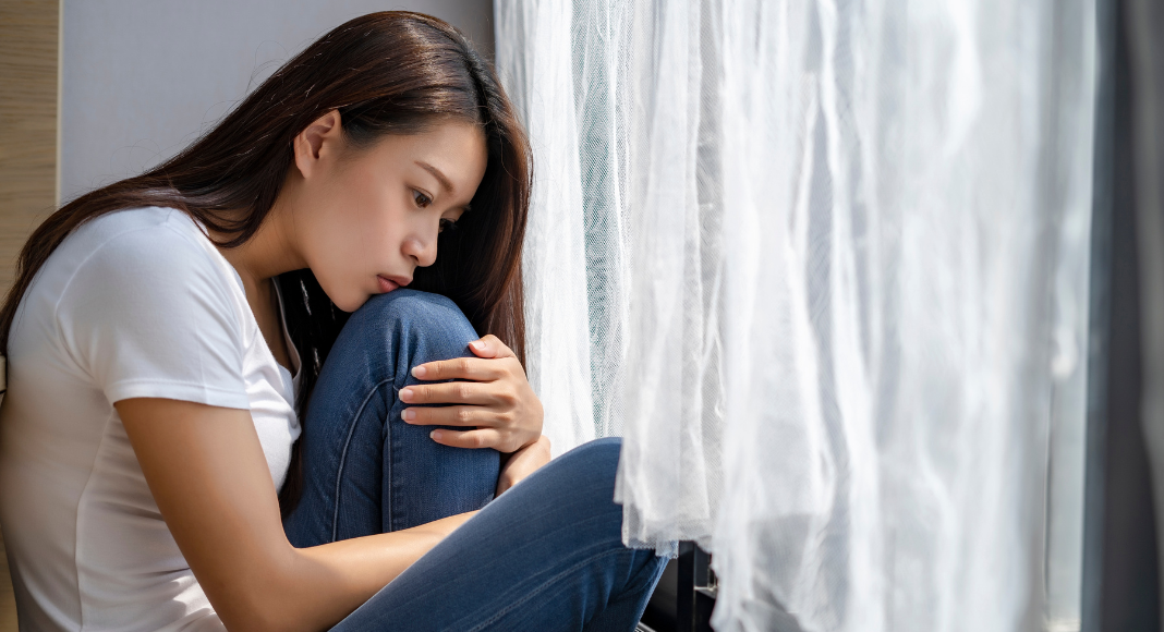 A woman disappointed holding her knees.