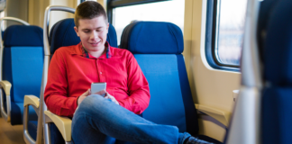 A boy riding a train alone.