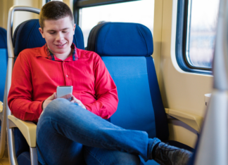 A boy riding a train alone.