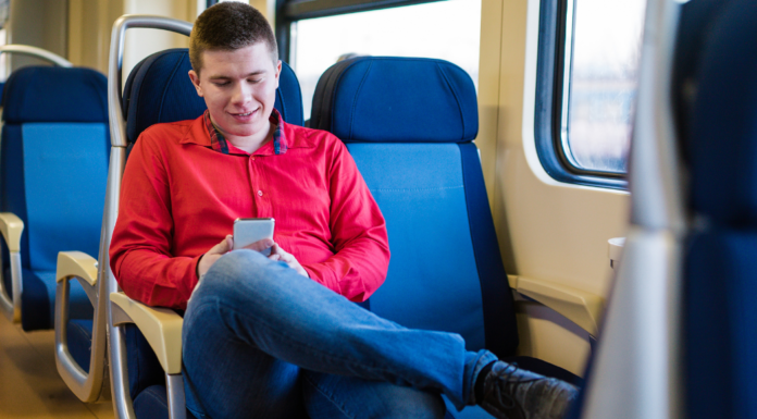 A boy riding a train alone.