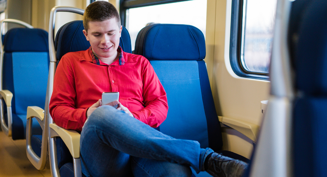 A boy riding a train alone.