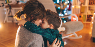 Skip the Holiday Stress and Have Yourself a Mediocre Christmas A mom kissing her son on Christmas.