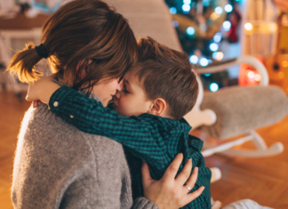 A mom kissing her son on Christmas.
