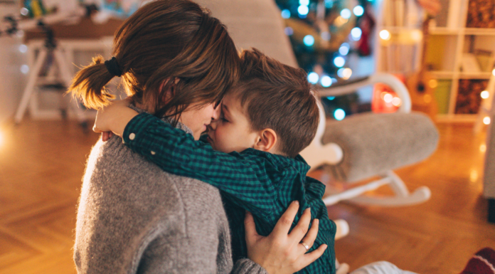 A mom kissing her son on Christmas.