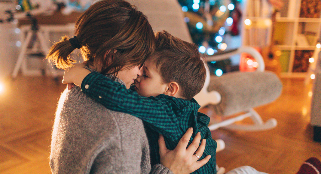 A mom kissing her son on Christmas. 