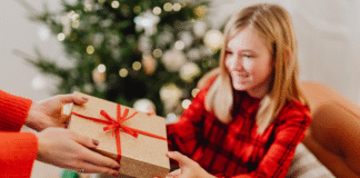Maintaining a Minimalist Christmas Giving a gift to a girl on Christmas.