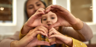 Making hearts with your hands.