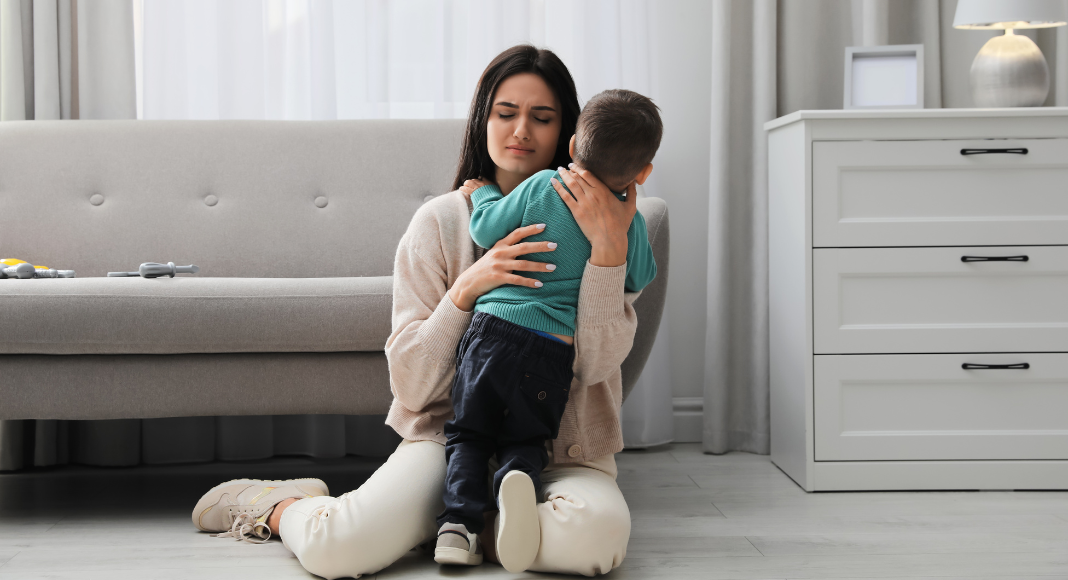 A mom holding her anxious son. 