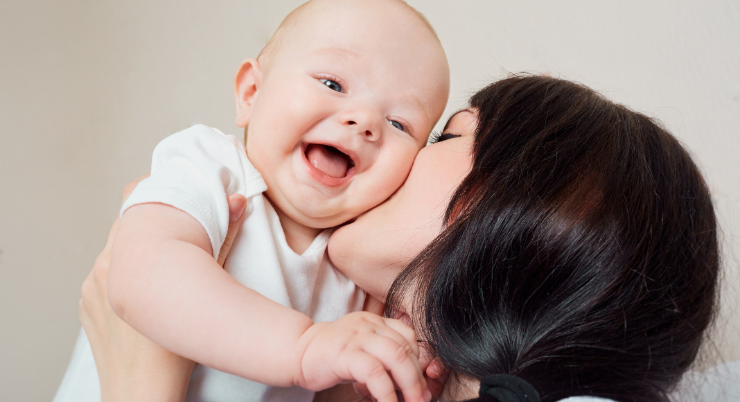 A mom kissing her baby.