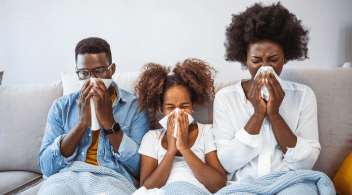 A sick family blowing their noses.