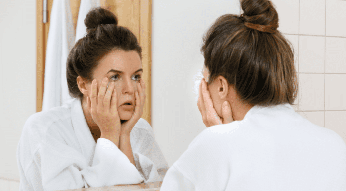Growing Old Gracefully? A woman looking in the mirror at her face.