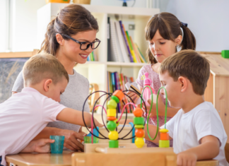 A preschool teacher working with children.