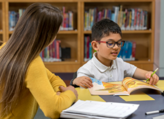A boy being tutored in the library.