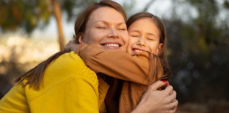 A mom hugging her daughter.