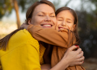 A mom hugging her daughter.