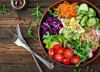 A vegetarian meal in a bowl next to a for and knife.