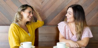 Is Talking With Friends About Money Taboo? Two women talking while drinking coffee.