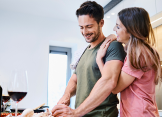 A couple making dinner together in the kitchen.
