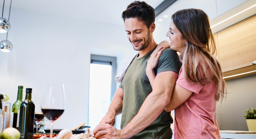 A couple making dinner together in the kitchen.