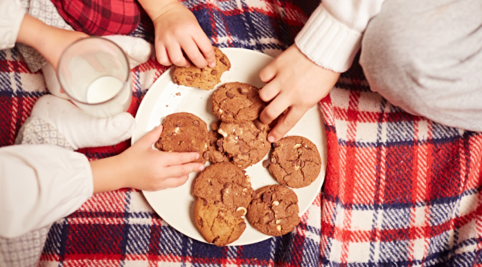 Kids grabbing cookies off of a plate.