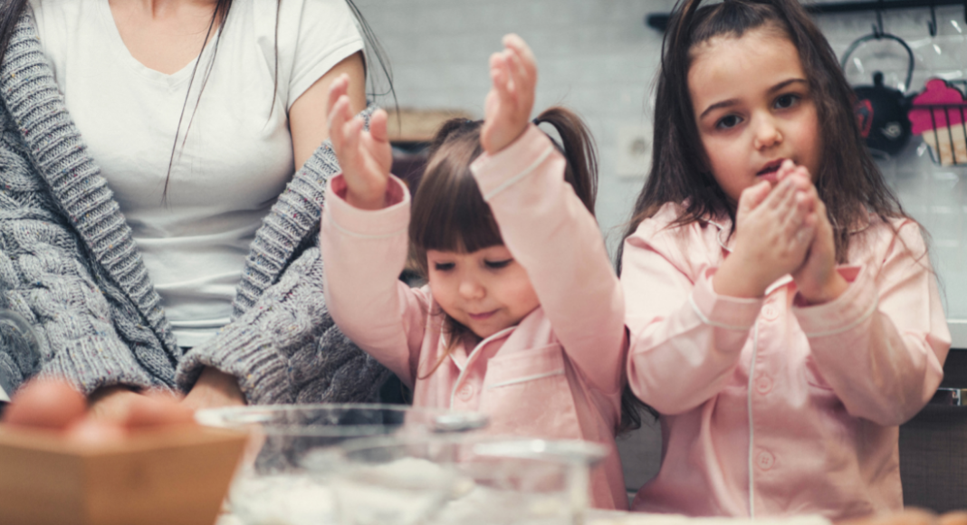 Two girls baking with a woman. 