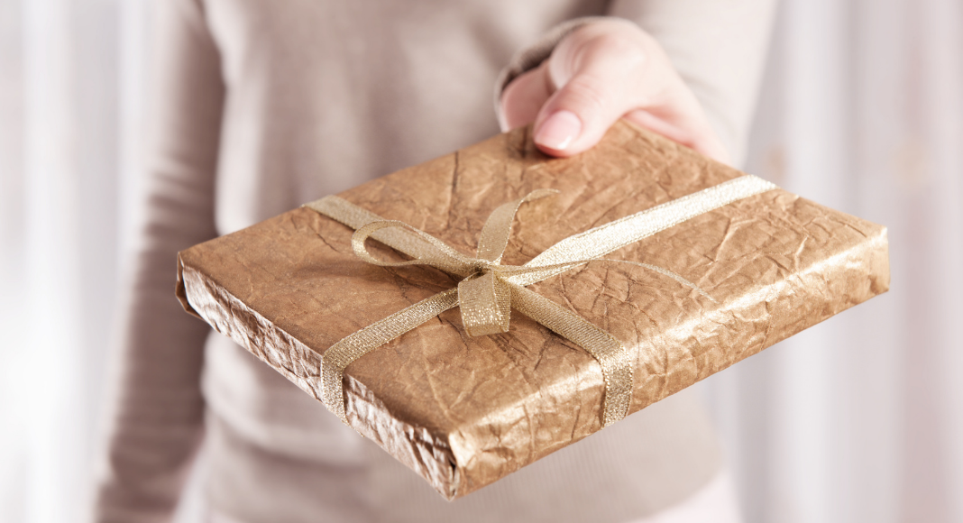 Woman holding a wrapped book.