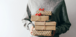 Woman holding wrapped holiday gifts.