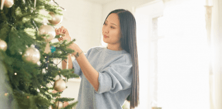 A woman decorating a Christmas tree.