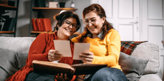 Two women looking at photographs and a photo album.