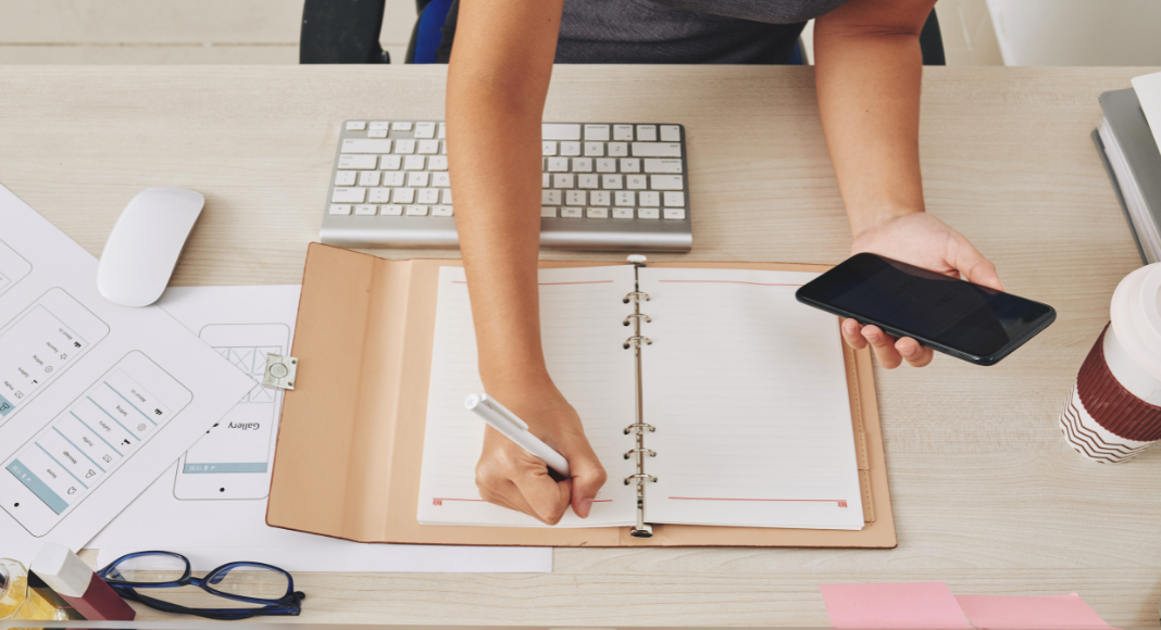 Woman at a desk filling in a calendar.