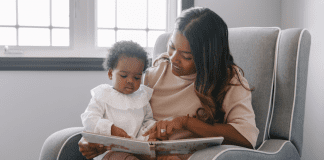A mom reading a book to a baby.