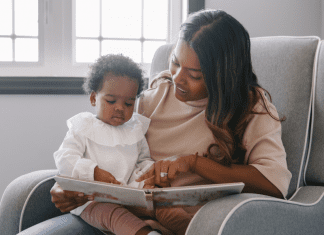 A mom reading a book to a baby.