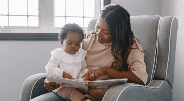 A mom reading a book to a baby.