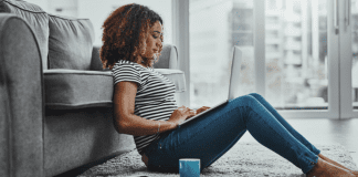 Woman sitting on the floor on her computer.