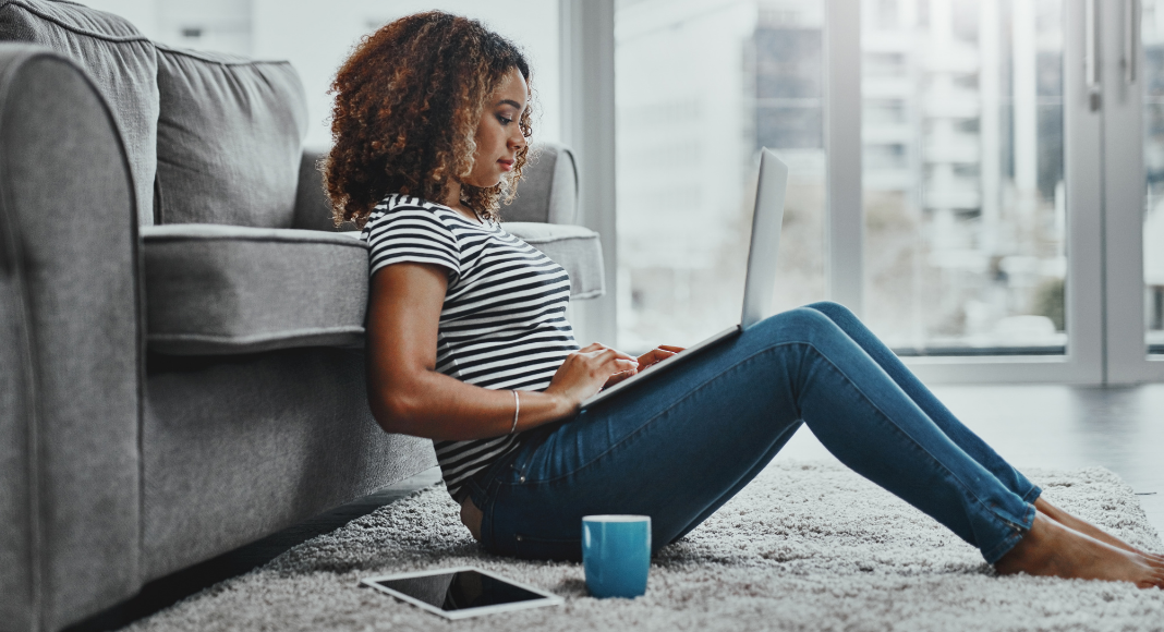 Woman sitting on the floor on her computer.
